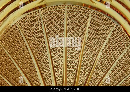 Detail of vintage amber yellow glass bowl with abstract lines and circles pattern. Stock Photo