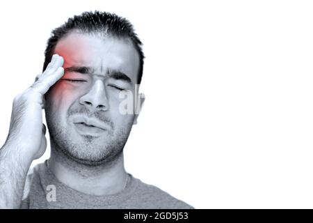 A young man grasps his head in anguish from pain or even stress.  Isolated over white with copyspace. Stock Photo
