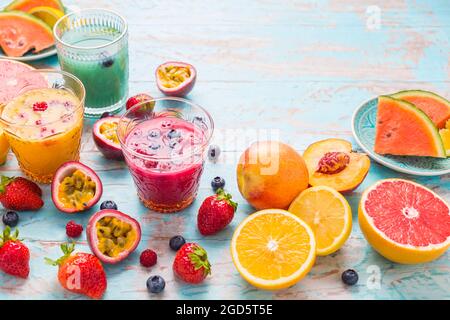 Variation of smoothies and refreshing drinks with fresh fruits for hot summer on blue background Stock Photo