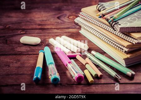 School supplies with exercise book and notepads on wooden background. Back to school concept. Stock Photo