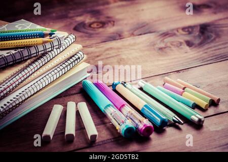School supplies with exercise book and notepads on wooden background. Back to school concept. Stock Photo