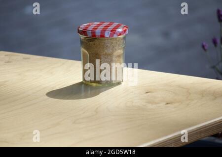 Jam jar and Demerara sugar on table Stock Photo