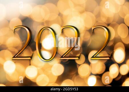 The year 2022 written on wooden cubes in gold luxury letters with shiny bokeh background, New Year celebration concept glitter Stock Photo