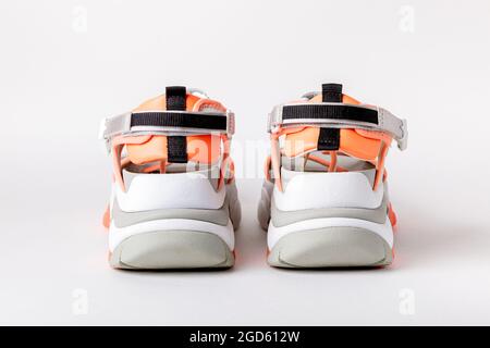 Women's, fashionable, sports sandals with orange accents on a white background. New youth shoes for girls. Stock Photo