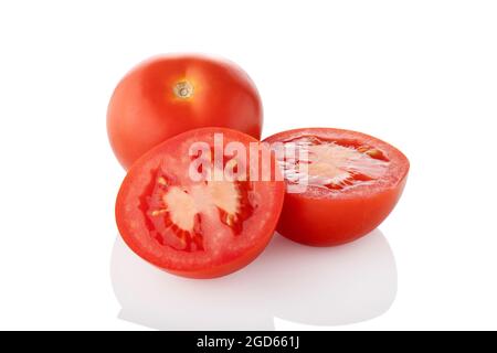 Sliced tomatoes. Two half one whole tomato on white background Stock Photo