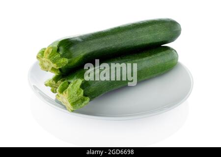 Courgette, zucchini. Three courgette in the white plate on a white background Stock Photo