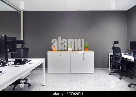 modern open space office with computer monitors on white desks Stock Photo