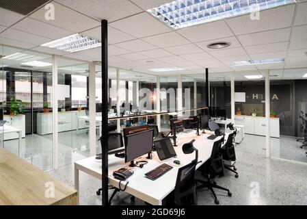Open space office with computer monitors on white desks Stock Photo