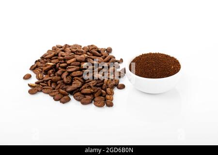 ground coffee and coffee beans. ground coffee and coffee combination in white bowl on white background Stock Photo