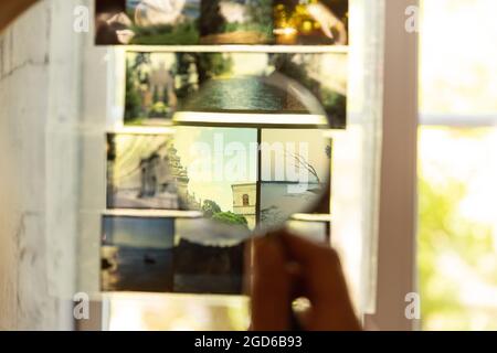 Close-up hands holding set of photo colored films, slides against window. Concept of fashion, occupation, job, education, art Stock Photo