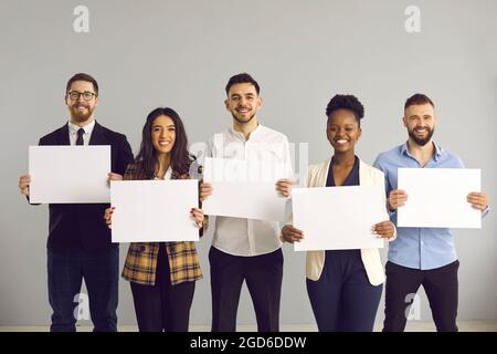 Multi-ethnic diverse business team holding empty paper sheets studio portrait Stock Photo