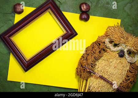 Yellow paper with owl and frame, chestnuts on green background. Place for text. Copy space Stock Photo