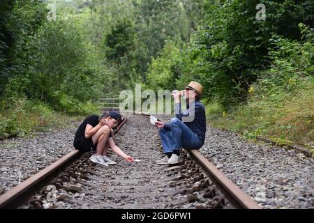 Man and boy playing cards on railway track Britain, Uk gamble gambling Stock Photo
