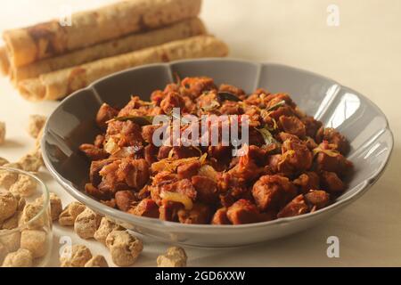 Dry roasted soya chunks with onions tomatoes and spices. Prepared with Kerala style meat masala in coconut oil. Served with indian flatbread. Shot on Stock Photo