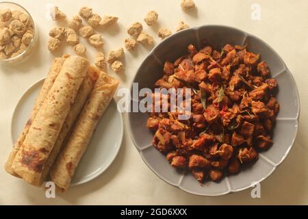 Dry roasted soya chunks with onions tomatoes and spices. Prepared with Kerala style meat masala in coconut oil. Served with indian flatbread. Shot on Stock Photo