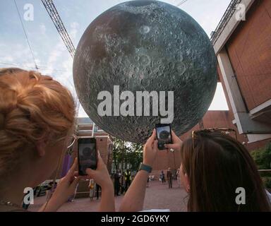 London UK 11 Aug 2021 An incredible lunar installation was unveiled as part of the Kensington   Chelsea Festival .Museum of the Moon is a touring artwork by UK artist Luke Jerram. Measuring seven metres in diameter, the moon features 120dpi detailed NASA imagery of the lunar surface. The optimum time to enjoy this lunar experience is at 7pm when it will come alive with music created by BAFTA and Ivor Novello award winning composer Dan Jones. Credit: Paul Quezada-Neiman/Alamy Live News Stock Photo