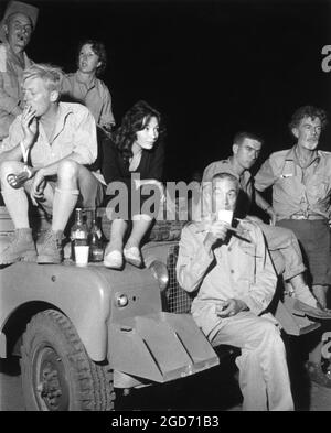 Producer DARRYL F. ZANUCK JULIETTE GRECO Director JOHN HUSTON and FRIEDRICH von LEDEBUR on set location candid in Africa during filming of THE ROOTS OF HEAVEN 1958 director JOHN HUSTON novel Romain Gary screenplay Romain Gary and Patrick Leigh-Fermor music Malcolm Arnold Darryl F. Zanuck Productions / Twentieth Century Fox Stock Photo