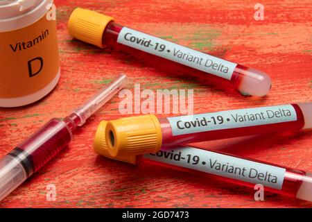 vacuum tube for blood collection, labeled Covid-19 - Variant Delta in a red back ground Stock Photo