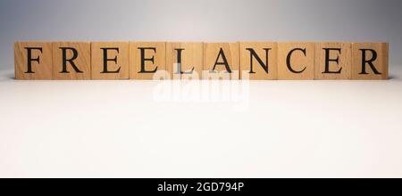 Freelancer was created from wooden cubes. News and journalism concepts. close up. Stock Photo