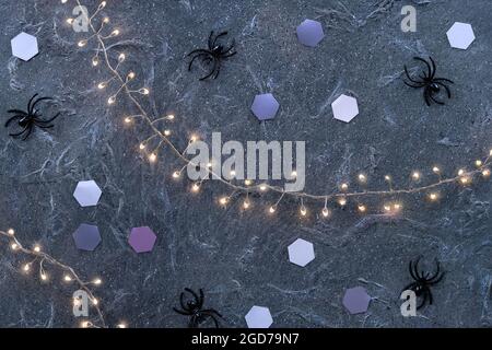 Minimal Halloween background with pale mint green spiders glow dark purple textured background . Flat lay, top view on background with paper hexagons Stock Photo