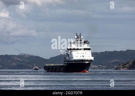 Offshore PSV platform supply vessel Island Chieftain at Byfjorde, off the port of Bergen, Norway. veteran steamship Stord ! in background Stock Photo