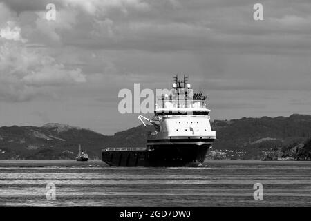 Offshore PSV platform supply vessel Island Chieftain at Byfjorde, off the port of Bergen, Norway. veteran steamship Stord ! in background Stock Photo