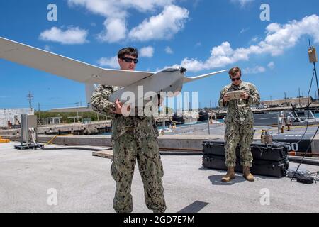 190507-N-RM689-1028SANTA RITA, Guam (May 7, 2019) Intelligence Specialist 1st Class Travis Rhoney, right, and Electronics Technician 3rd Class Michael Lemay,  both assigned to Coastal Riverine Squadron (CRS) 2, conduct a system check of an RQ-20B Puma unmanned aerial system in preparation for a visit by Republic of Palau Vice President Raynold B. Oilouch and his delegation during Oilouch's visit to U.S. Naval Base Guam.  CRS-2 is assigned to Costal Riverine Group 1, Detachment Guam, and is capable of conducting maritime security operations across the full spectrum of naval, joint and combined Stock Photo
