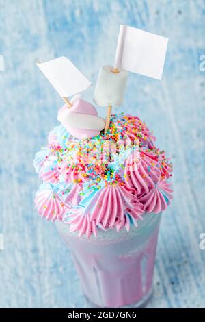 Blue and pink milkshake decorated with marshmallows on a blue background. Stock Photo