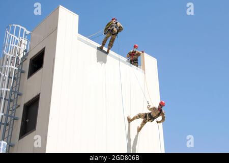 U.S. Air Force Staff Sgt. Justin Rice, center, 60th Civil Engineer Squadron lead firefighter, watches as Lt. Col. Matthew Suhre, right, 60th Mission Support Group deputy commander, and Staff Sgt. Daniel Robinson, 60th CES lead firefighter, rappel down a structure April 19, 2021, at the Travis Fire and Emergency Services training facility at Travis Air Force Base, California. The training demonstration provided senior leadership with a clear picture of the technical rescue capabilities for multi-story building and confined space rescues conducted by Travis AFB emergency response personnel. (U.S Stock Photo