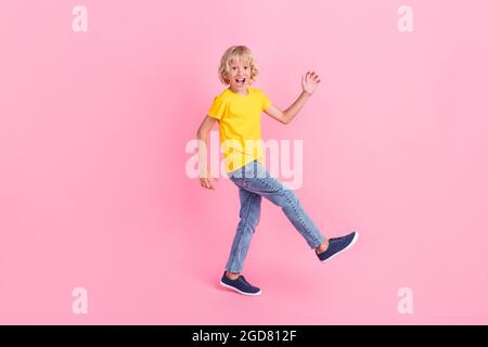 Full length profile side photo of young excited little boy happy positive smile go walk step isolated over pink color background Stock Photo