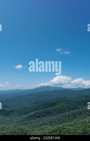 Forest covered foothills of the Blue Ridge Mountains on North Caroilna, NC, USa with brilliant blue sky and puffy white clouds Stock Photo
