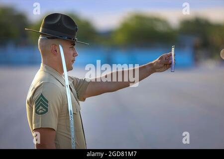 Staff Sgt. Daniel L. Avila Jr., senior drill instructor with Alpha Company, 1st Recruit Training Battalion, observes his drill card during Final Drill aboard Marine Corps Recruit Depot Parris Island, S.C., May 19, 2021. Final Drill tests drill instructors on their ability to give drill commands and tests recruits on their ability to execute movements properly. (U.S. Marine Corps photo by Lance Cpl. Samuel C. Fletcher) Stock Photo