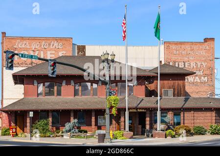 Toppenish, WA, USA - August 09, 2021; The city hall in Toppenish in Yakima County Washington.  Two flag poles fly the USA and Washington flags Stock Photo