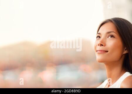 Happy young Asian woman natural beauty looking up pensive thinking of successful life and goal achievement, hopeful for the future career. Beautiful Stock Photo