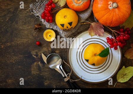 Halloween day decoration party. Halloween wooden table setting with pumpkins and tangerines. Top view flat lay background. Copy space. Stock Photo