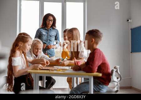 Happy boys and girls using wooden math tablet Stock Photo
