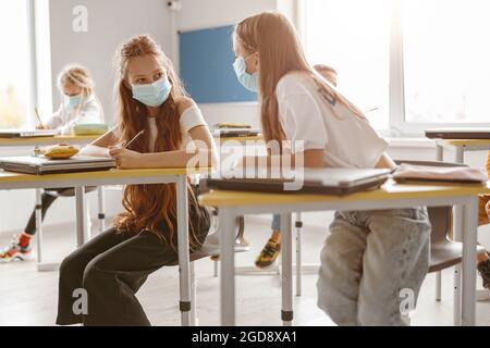 Kids using pencils and notebooks while writing test together in school Stock Photo