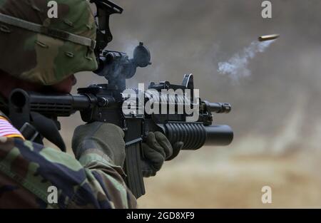 US Army (USA) Private First Class (PFC) Michael Freise, assigned to 1st Battalion, 72nd Armor Regiment, fires an M4/M4A1 5.56 mm Carbine rifle during a reflex firing exercise held at Rodriguez Live Fire Complex, Republic of Korea (KOR).  (USAF PHOTO BY SSGT SUZANNE DAY 050323-F-9629D-056) Stock Photo