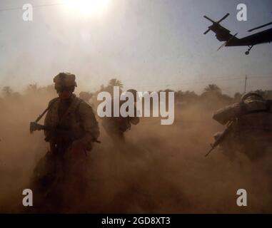 US Army (USA) Soldiers, 1st Battalion (BN), 41st Infantry Regiment (INF REGT), 3rd Brigade (BDE), 1st Armored Division (AD), Fort Riley, Kansas (KS), scan the landing zone at Baghdad, Iraq, for possible hostile forces.  The Soldiers are providing security while their unit builds a play set for children at a local school during Operation IRAQI FREEDOM.  (USAF PHOTO BY TSGT RUSSELL E. COOLEY IV 050826-F-9712C-131) Stock Photo