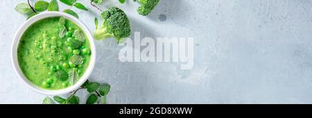 Vegan green soup panorama. Broccoli and green peas puree, shot from the top with copy space. Vegan menu panoramic header Stock Photo