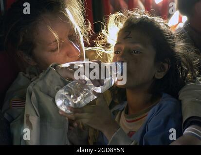 US Army (USA) Sergeant (SGT) Kornelia Rachwal gives a young Pakistani girl a drink of water as they are airlifted from Muzaffarabad to Islamabad, Pakistan, aboard a USA CH-47 Chinook helicopter. The Department of Defense (DoD) Pakistan Earthquake Relief is part of a multinational effort to provide humanitarian assistance and support to Pakistan (PAK) and parts of India (IND) and Afghanistan (AFG) following a devastating earthquake.  (USAF PHOTO BY TSGT MIKE BUYTAS 051019-F-9085B-154) Stock Photo