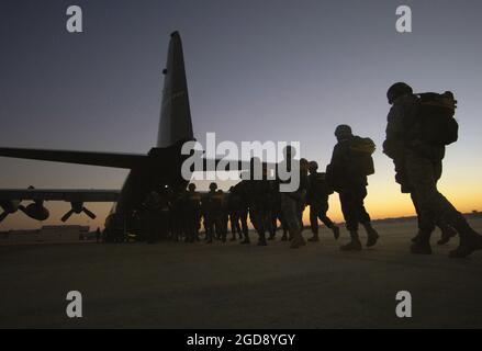 US Army (USA) paratroopers assigned to the 82nd Airborne Division (AD), Fort Bragg, North Carolina (NC), board a US Air Force (USAF) C-130 Hercules aircraft at Pope Air Force Base (AFB), North Carolina (NC), for the 8th Annual Randy Oler Memorial Operation Toy Drop. The international community relations operation is designed to collect toys for children of military families on Fort Bragg and Pope AFB as well as those in the surrounding communities. USA paratroopers participate in the operation by donating a toy in exchange for a chance to make a non-tactical parachute jump with German and Iris Stock Photo