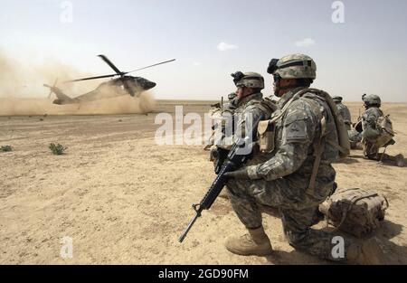A US Army (USA) Task Force (TF) No Mercy (TFNM), Bravo Company (B Co), 1st Battalion (BN), 207th Aviation Regiment (1/207th AVN), 101st Airborne Division (ABN) UH-60 Black Hawk (Blackhawk) utility helicopter prepares to land to pick-up USA 1st Brigade, 1st Armored Division (AD), Soldiers who are participating in an air assault combat patrol in Tall Afar, Ninawa Province (Al-Jazeera Desert area), Iraq (IRQ), conducted during Operation IRAQI FREEDOM.  (USAF PHOTO BY SSGT AARON D. ALLMON II 060322-F-7823A-121) Stock Photo