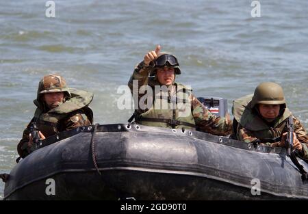 North Dakota Army National Guard (NDARNG) Sergeant (SGT) Kayla G. Gartner (left), NDARNG SGT Royal P. Hosfield, and Officer Candidate Janet K. Nitschke, all of the 957th Engineer Company (Multi-Role Bridge), Bismarck, North Dakota (ND), practice river maneuvers in a Zodiac boat on the Missouri River near Bismarck, ND.  The NDARNG troops are training to use the boats for future deployments.  (USAF PHOTO BY SMSGT DAVID H. LIPP 060707-F-0681L-149) Stock Photo