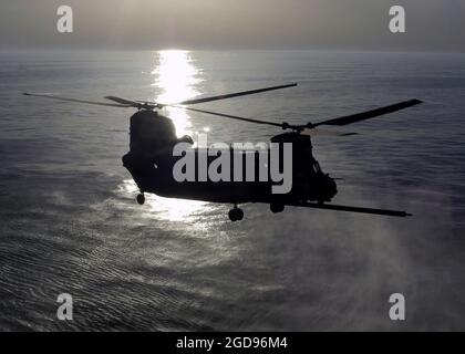A US Army (USA) 160th Special Operations Aviation Regiment (SOAR) MH-47 Chinook Special Operations (SOF) helicopter flies over the Atlantic Ocean as it approaches the flight deck of the Wasp Class Amphibious Assault Ship USS WASP (LHD 1) during the deck landing qualification program.  (US NAVY PHOTO BY PH3 TIMOTHY BENSKEN 060419-N-3527B-115) Stock Photo