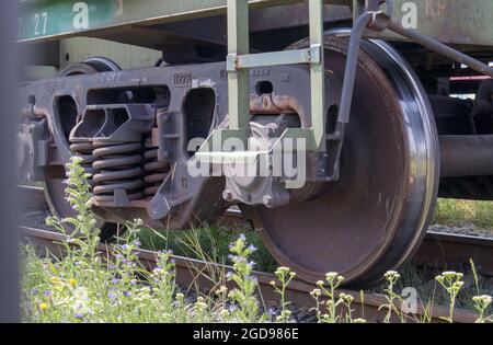 The undercarriage of the carriage with wheels and springs. Passenger train, freight train. Industrial railway wheels close up Stock Photo