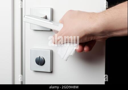 Open door handle with wet wipe on hand close up view Stock Photo