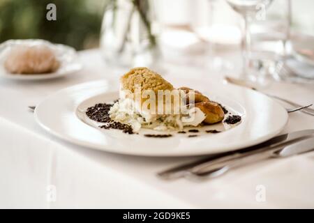 Plate of bacalhau (salted cod) fillet served with portion of stewed ...