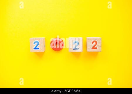 Numbers 2022 from childrens cubes and toys on a bright yellow background. New Year Stock Photo
