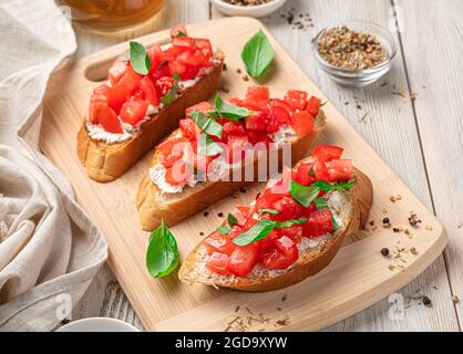 Sandwiches with tomato, feta and basil, traditional bruschetta. Stock Photo